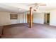 A large basement with outdated carpeting, exposed support beam, and ceiling fan at 3670 Whirlaway Dr, Decatur, GA 30034