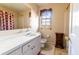 Bathroom featuring natural light, single sink vanity, tile flooring, and shower/tub combo at 3670 Whirlaway Dr, Decatur, GA 30034