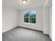 Neutral bedroom features plush carpeting and a window with a lush green view at 7240 Raintree Loop, Jonesboro, GA 30236