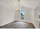 Bright dining room boasts modern chandelier and arched window with view of the yard at 7240 Raintree Loop, Jonesboro, GA 30236