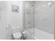 Clean bathroom featuring a shower with bathtub, toilet, and white marbled tile at 108 Vinings Forest Se Cir, Smyrna, GA 30080