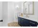 Stylish bathroom vanity with a navy blue cabinet, golden fixtures, a decorative mirror, and hardwood floors at 108 Vinings Forest Se Cir, Smyrna, GA 30080