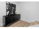 Hallway featuring a black textured cabinet with silver handles, contemporary art, and hardwood flooring at 108 Vinings Forest Se Cir, Smyrna, GA 30080