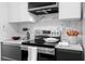 Modern kitchen with black and white cabinets, stainless steel appliances, and marble backsplash at 108 Vinings Forest Se Cir, Smyrna, GA 30080