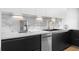 Sleek kitchen with black lower cabinets, white upper cabinets, marble backsplash, and modern stainless steel appliances at 108 Vinings Forest Se Cir, Smyrna, GA 30080