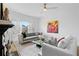 Bright living room featuring a grey sofa, white couch, and modern art, illuminated by a sleek ceiling fan at 108 Vinings Forest Se Cir, Smyrna, GA 30080