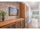 Hallway with exposed brick wall, wooden storage, and view of city buildings through the window at 215 Piedmont Ne Ave # 1110, Atlanta, GA 30308