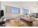 Bright living room with floor-to-ceiling windows, plush seating, and hardwood floors at 215 Piedmont Ne Ave # 1110, Atlanta, GA 30308