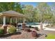 Community pool area featuring lounge chairs, patio furniture, a gazebo, and well-maintained landscaping at 4310 Wellbrook Ct, Douglasville, GA 30135