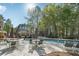 Community pool area with tables, umbrellas, lounge chairs, and clubhouse in a park-like setting at 4310 Wellbrook Ct, Douglasville, GA 30135