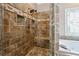 Custom tile shower with built-in seat and niche offers spa-like experience in the luxurious main bathroom at 4310 Wellbrook Ct, Douglasville, GA 30135