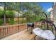 Wooden deck features a comfortable swing, grill, with green trees in the background, great for outdoor relaxation at 1902 Glen Ivy, Marietta, GA 30062