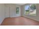Well-lit bedroom with hardwood floors and multiple windows offering picturesque views of the outdoors at 553 Somersby Dr, Dallas, GA 30157