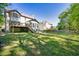 Grassy backyard featuring trees, two-story home, and a sloped lawn at 1420 Midland Way, Lawrenceville, GA 30043