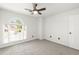 Bright bedroom features neutral carpet, white trim, ceiling fan, and natural light from a large window at 1420 Midland Way, Lawrenceville, GA 30043
