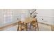 Bright dining room featuring hardwood flooring, white walls, two windows, and a wooden table set for four at 1420 Midland Way, Lawrenceville, GA 30043