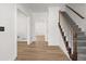 Bright foyer with hardwood floors, white walls, and a staircase featuring carpeted treads and wood railing at 1420 Midland Way, Lawrenceville, GA 30043
