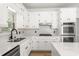 Contemporary kitchen with bright white cabinets, stainless appliances, and sleek quartz countertops and backsplash at 1420 Midland Way, Lawrenceville, GA 30043