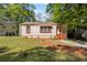 Charming tan home featuring a well maintained lawn and complemented by mature trees at 2383 Baker Nw Rd, Atlanta, GA 30318