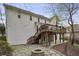 Exterior backyard showcasing a stone patio with fire pit and a wooden deck overlooking the grounds at 4284 Windy Gap Nw Ct, Kennesaw, GA 30144