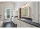 Well-lit bathroom with dual vanities, granite countertops, and ample storage in white cabinets at 4284 Windy Gap Nw Ct, Kennesaw, GA 30144