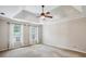Spacious bedroom with tray ceiling, neutral carpet, and double windows at 4284 Windy Gap Nw Ct, Kennesaw, GA 30144