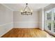 Formal dining room with classic chandelier, hardwood floors, and large windows for natural light at 4284 Windy Gap Nw Ct, Kennesaw, GA 30144