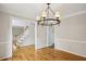 Chandelier lit dining room showcasing entryways, hardwood floors, and staircase at 4284 Windy Gap Nw Ct, Kennesaw, GA 30144