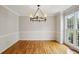 Neutral formal dining room features beautiful hardwood floors and a hanging chandelier at 4284 Windy Gap Nw Ct, Kennesaw, GA 30144
