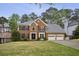 Traditional brick home featuring a well-manicured lawn, a two-car garage, and classic architectural details at 4284 Windy Gap Nw Ct, Kennesaw, GA 30144