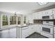 Bright kitchen with white cabinets, modern appliances, and an adjacent dining area with deck access at 4284 Windy Gap Nw Ct, Kennesaw, GA 30144