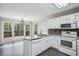 Well-lit kitchen with white cabinets, modern appliances, and an adjacent dining area with sliding glass doors to the deck at 4284 Windy Gap Nw Ct, Kennesaw, GA 30144
