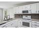 A bright kitchen features stainless steel appliances, white cabinets, and a gray countertop at 4284 Windy Gap Nw Ct, Kennesaw, GA 30144