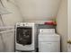 A dedicated laundry area showcasing a modern washer and dryer set, along with metal shelving for storage at 4284 Windy Gap Nw Ct, Kennesaw, GA 30144