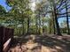 View of wooded backyard with mature trees, partial fence, and sunlight at 5130 English Dr, Cumming, GA 30041
