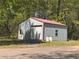 View of the detached garage with metal siding, providing ample space for parking and storage at 5130 English Dr, Cumming, GA 30041