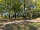 Beautiful lot with mature trees and a gravel driveway leads to the property at 5130 English Dr, Cumming, GA 30041
