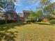 Spacious back yard featuring lush green grass, mature trees, a patio, and a wood fence at 5763 Mitchell Chase Trl, Mableton, GA 30126