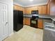 Well-lit kitchen featuring black appliances, ample wood cabinetry, and durable countertops at 5763 Mitchell Chase Trl, Mableton, GA 30126