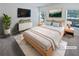 Staged main bedroom featuring a bed with nightstands, dresser with television, and windows with blinds at 5763 Mitchell Chase Trl, Mableton, GA 30126
