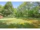 Large, grassy backyard bordered by mature trees with shady spots for relaxing or playing at 120 Westwood Nw Dr, Marietta, GA 30064