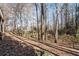 View of a lush wooded backyard featuring a rustic wooden fence and beautiful natural surroundings at 2125 Fairfax Dr, Alpharetta, GA 30009