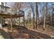The backyard offers a deck above a covered patio area that overlooks a lush, wooded landscape with a rustic fence at 2125 Fairfax Dr, Alpharetta, GA 30009