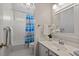 This bright bathroom offers a shower and tub combo, decorative shower curtain, and a large mirror at 2125 Fairfax Dr, Alpharetta, GA 30009