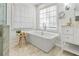 Bright bathroom featuring a freestanding tub, marble floors, and natural light from a large window at 2125 Fairfax Dr, Alpharetta, GA 30009