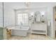 Bright bathroom with large tub, marble floors, double vanity, a crystal chandelier, and wall lighting at 2125 Fairfax Dr, Alpharetta, GA 30009
