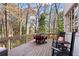 Inviting deck with wooded views, a table with chairs, and rocking chairs, perfect for outdoor relaxation and entertainment at 2125 Fairfax Dr, Alpharetta, GA 30009