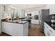 A modern kitchen with white cabinetry, dark countertops, stainless steel appliances, and a large bay window at 2125 Fairfax Dr, Alpharetta, GA 30009