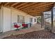 Covered patio with red cushioned chairs and wooded views, a perfect spot for enjoying the outdoors in comfort at 2125 Fairfax Dr, Alpharetta, GA 30009
