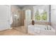 Modern bathroom features a glass-enclosed shower, soaking tub, and stylish tile work at 347 Woodridge Pass, Canton, GA 30114